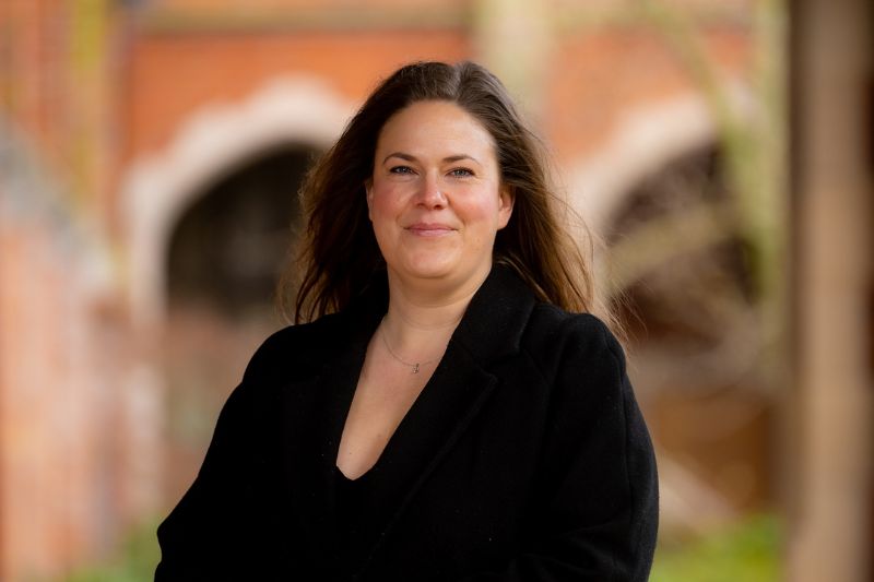 Catharina Bartholomew headshot in front of red brick background